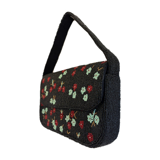 Black beaded handbag with red and green floral patterns on a white background