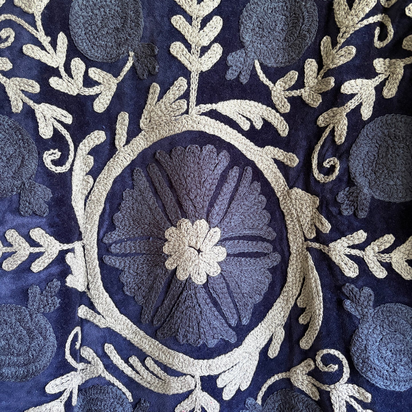 Close-up of intricate floral embroidery on a dark fabric background