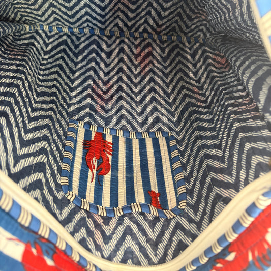Close-up of a bag with a zigzag pattern and red lobster design.