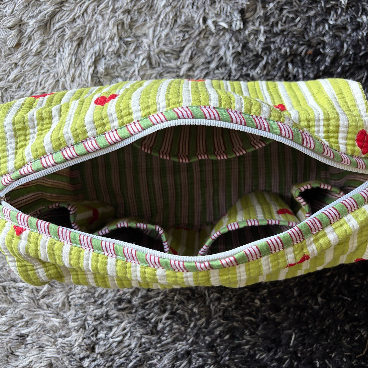 Quilted green and white make up bag with red hearts.