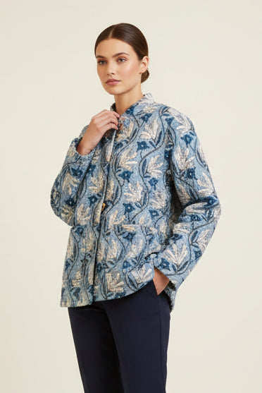 Woman wearing a blue patterned shirt against a beige background