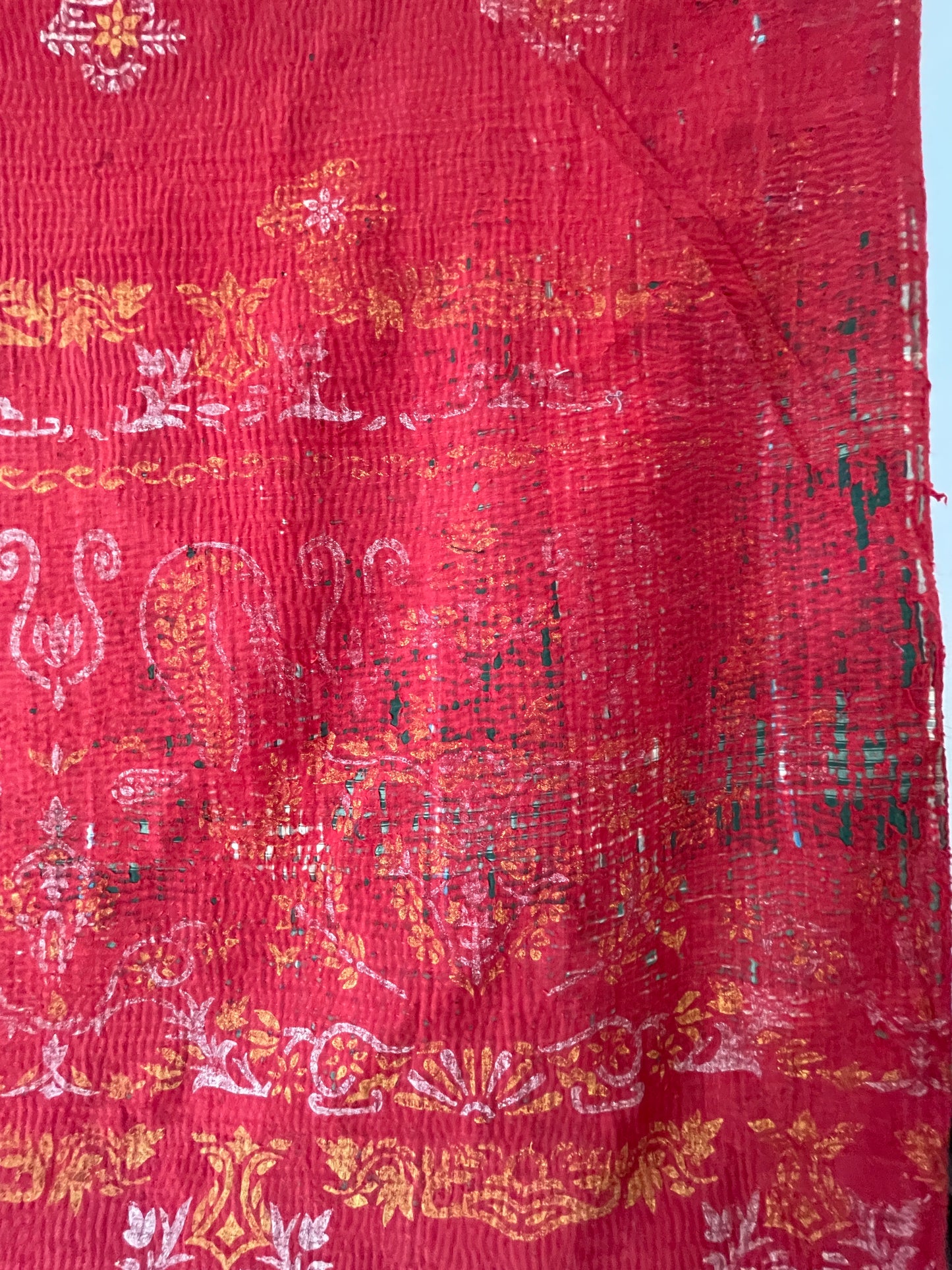 Red fabric with intricate white, yellow, and black patterns vintage kantha bed throw