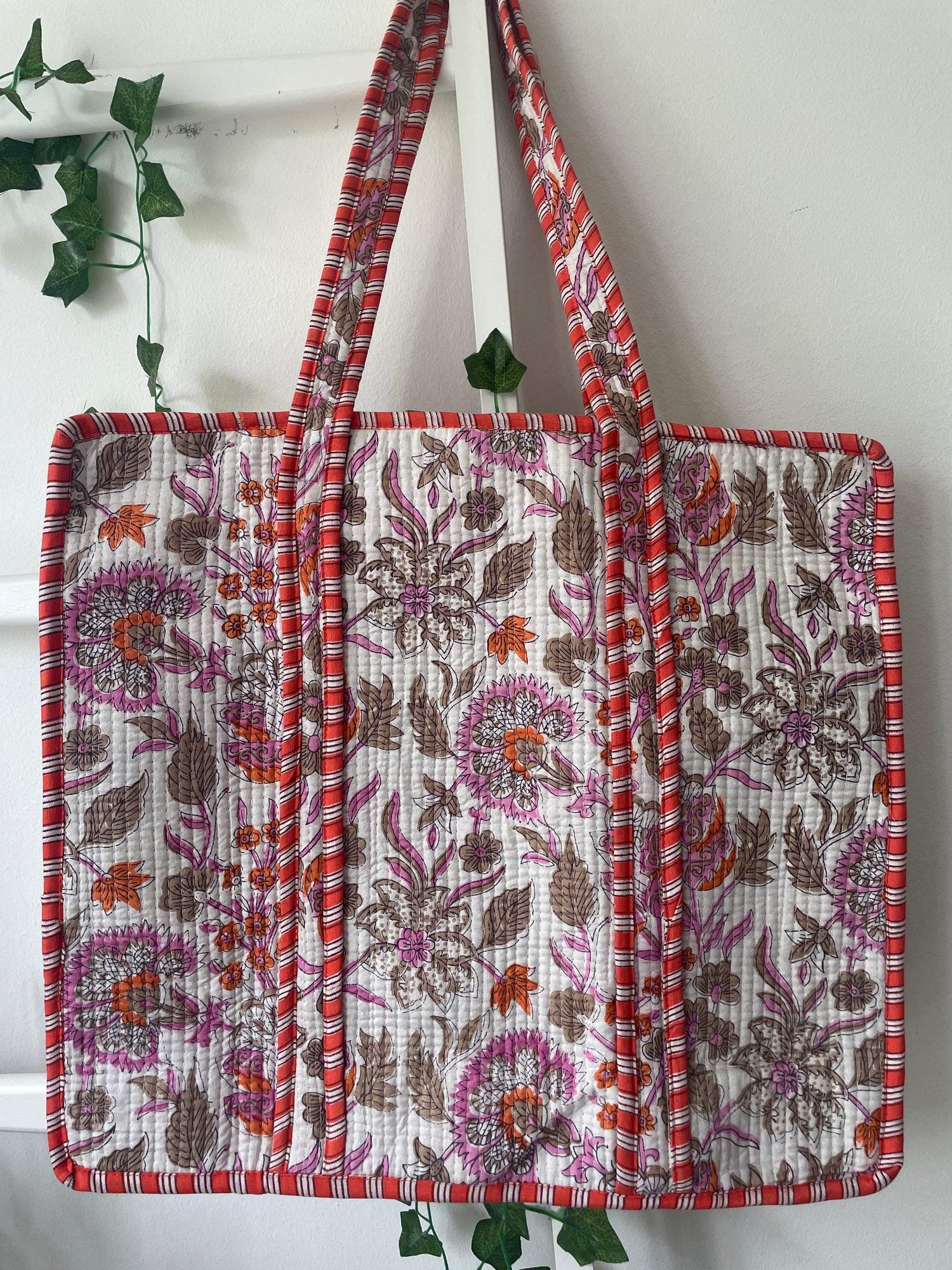 Floral patterned bag with a strap on a white background