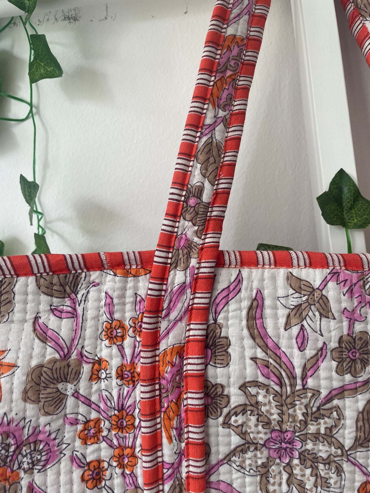 loral-patterned Tote bag with red and orange accents on a white background.