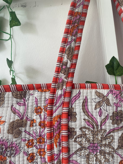 loral-patterned Tote bag with red and orange accents on a white background.
