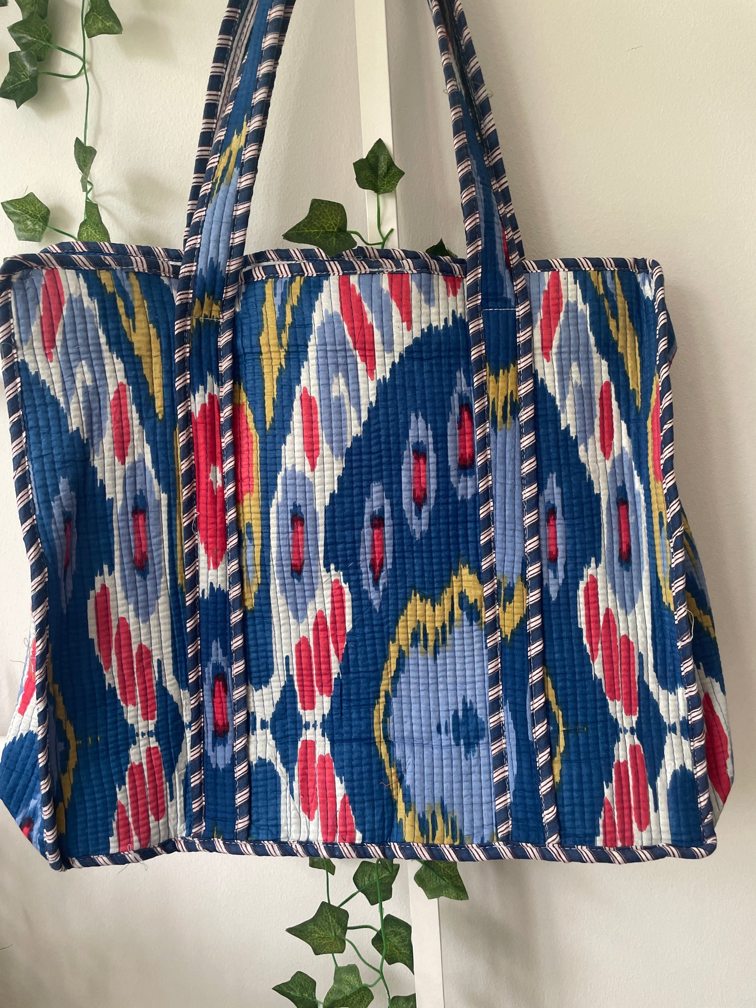 Quilted bag with a blue and red pattern on a light background