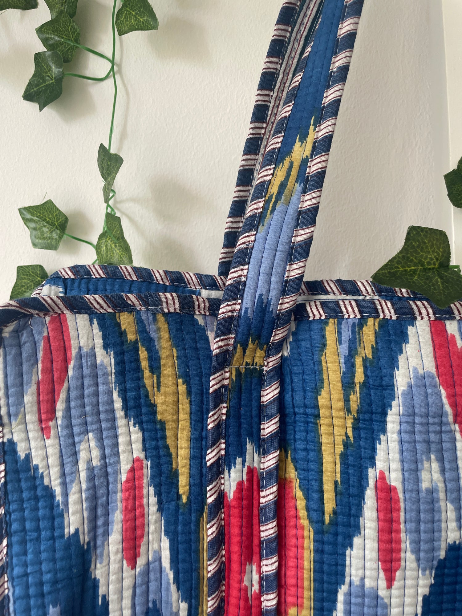 Colorful quilted bag with geometric pattern on a white background