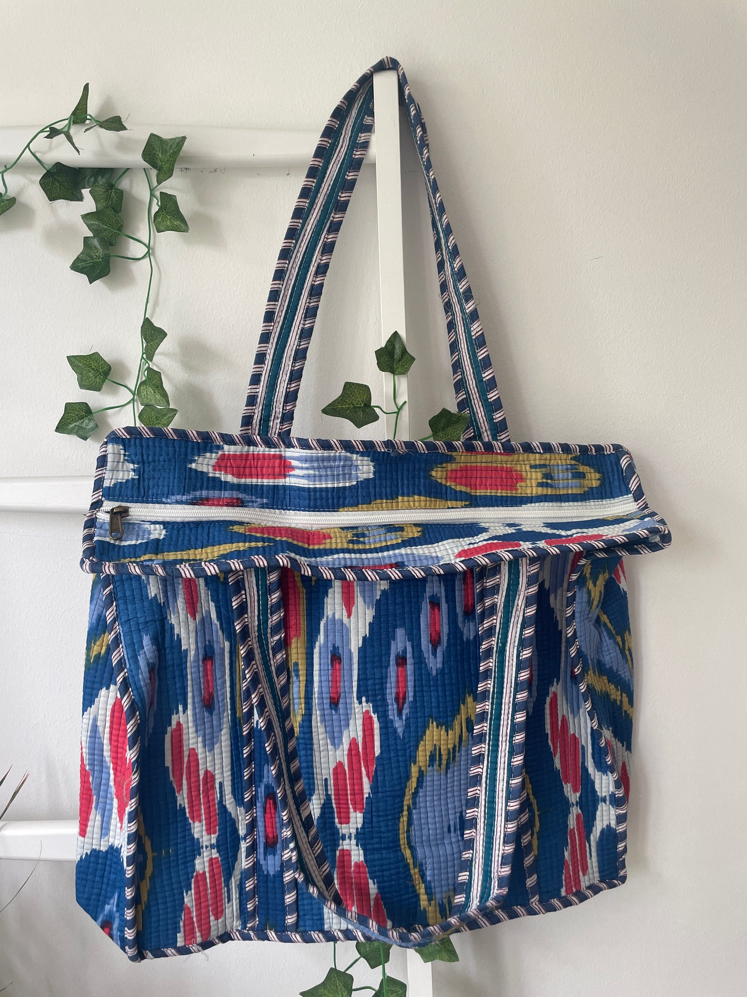 Blue patterned bag with a strap on a white background