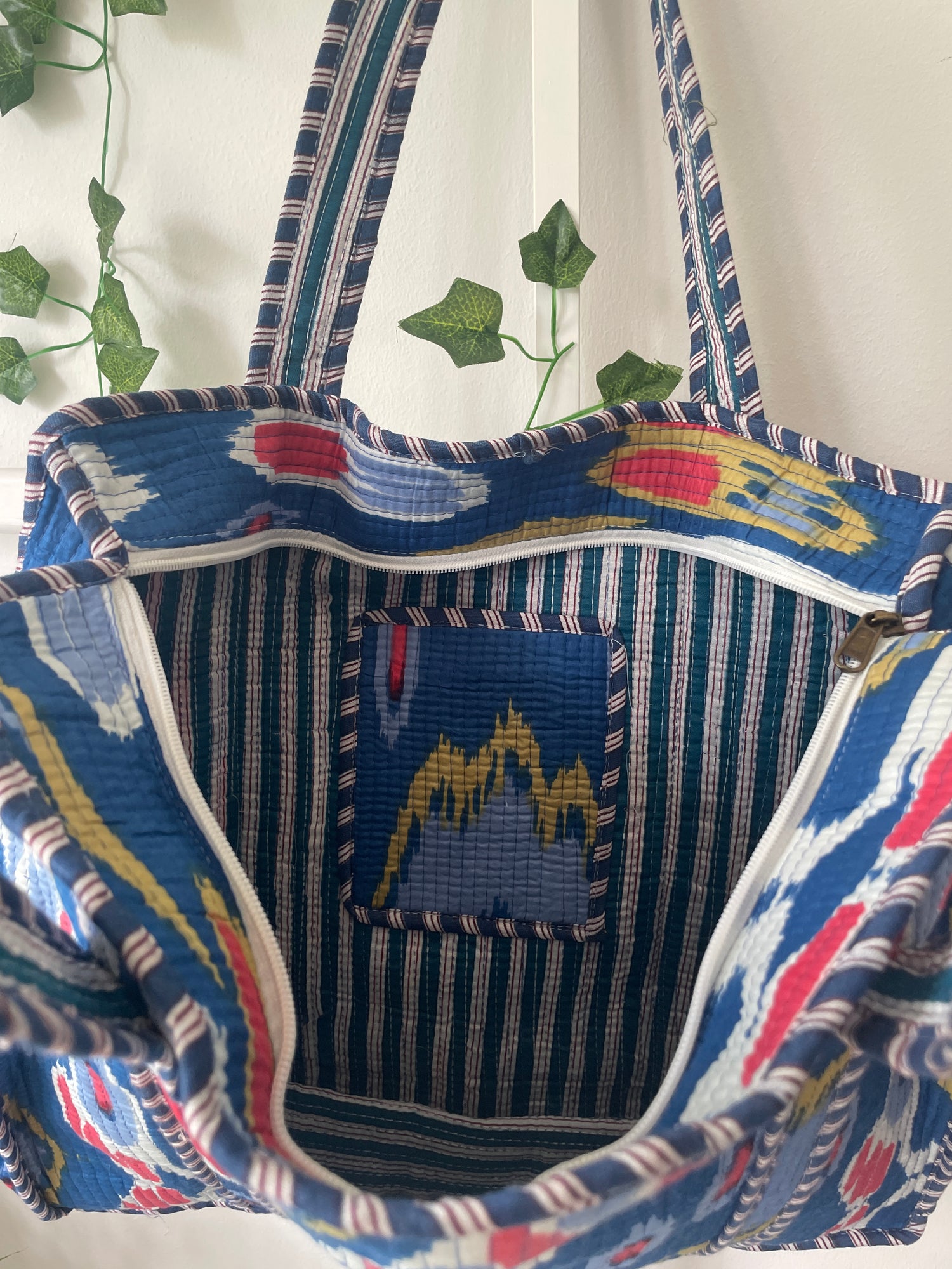 Close-up of a colorful fabric bag with intricate patterns on a white background.