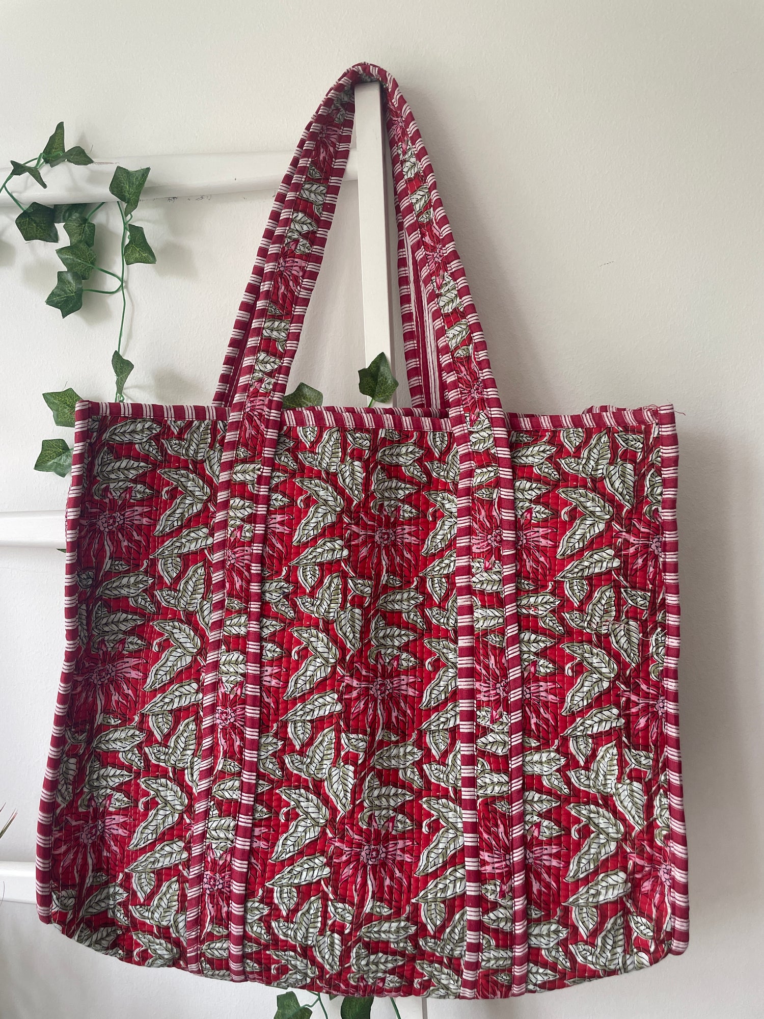 Red and green patterned tote bag on a white background