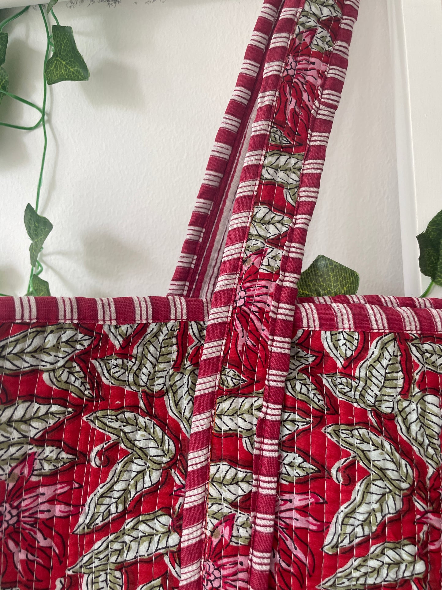 Close-up of red fabric with green leaf pattern on a white background