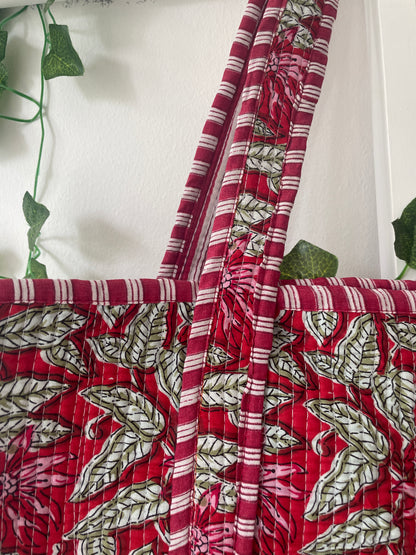 Close-up of red fabric with green leaf pattern on a white background