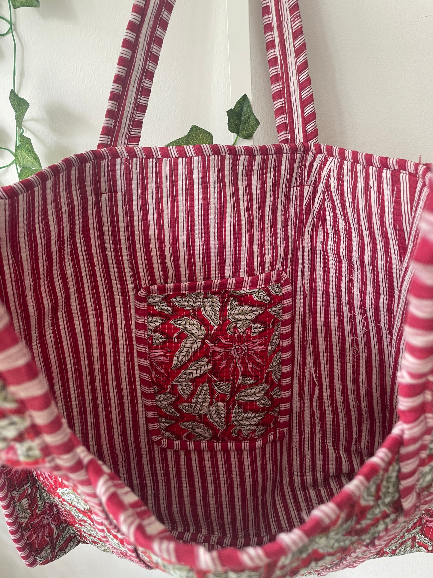 Red and white striped fabric with a floral patterned pocket on a white background