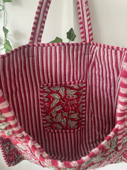 Red and white striped fabric with a floral patterned pocket on a white background