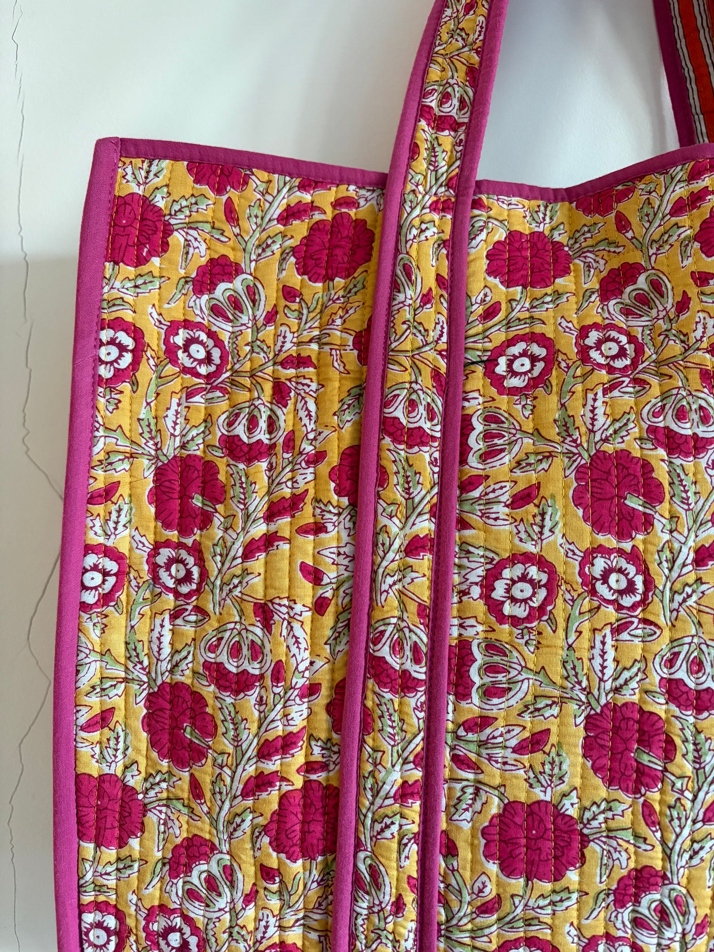 Floral patterned tote bag with pink and yellow colors on a white background