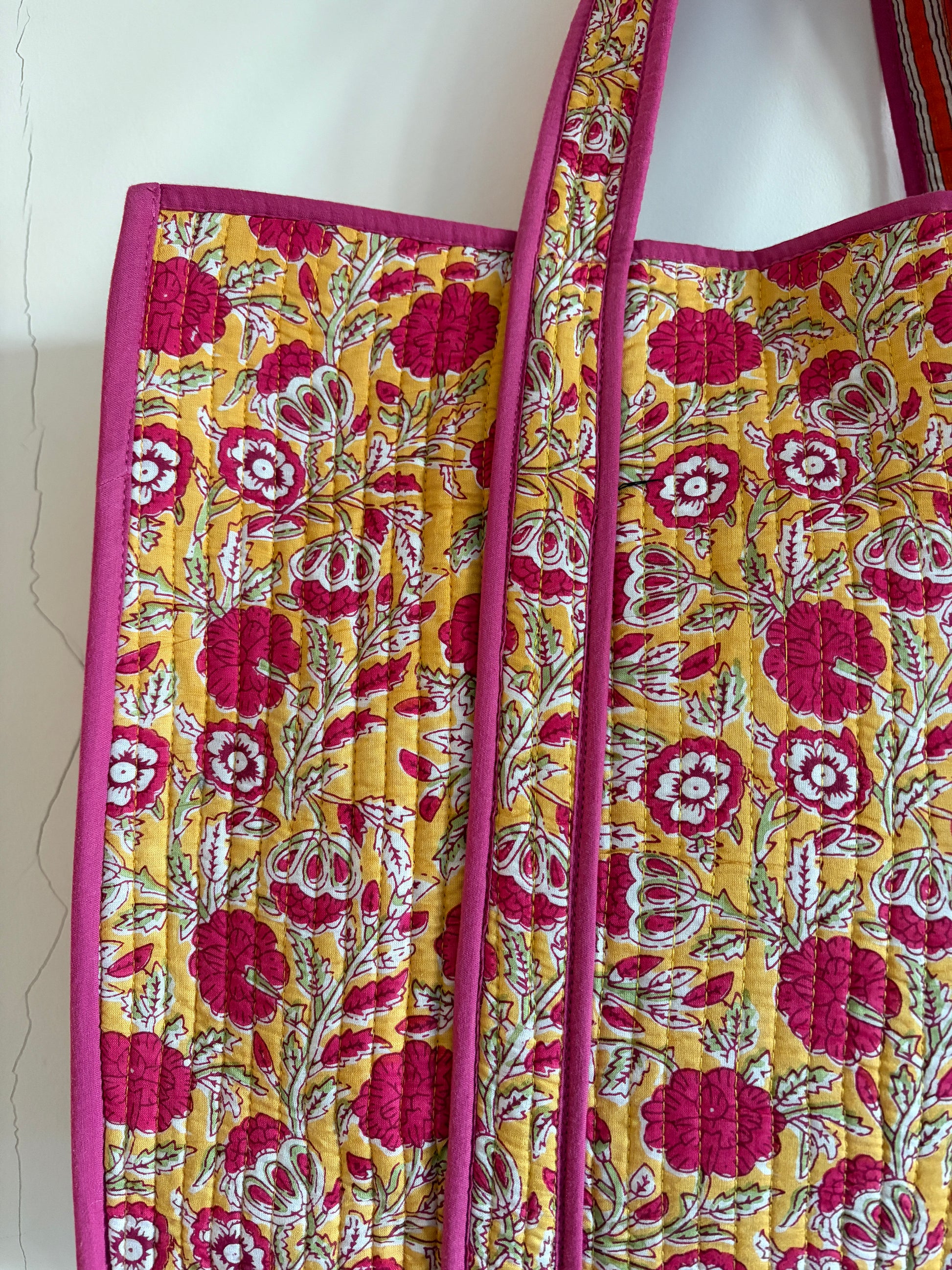 Floral patterned tote bag with pink and yellow colors on a white background