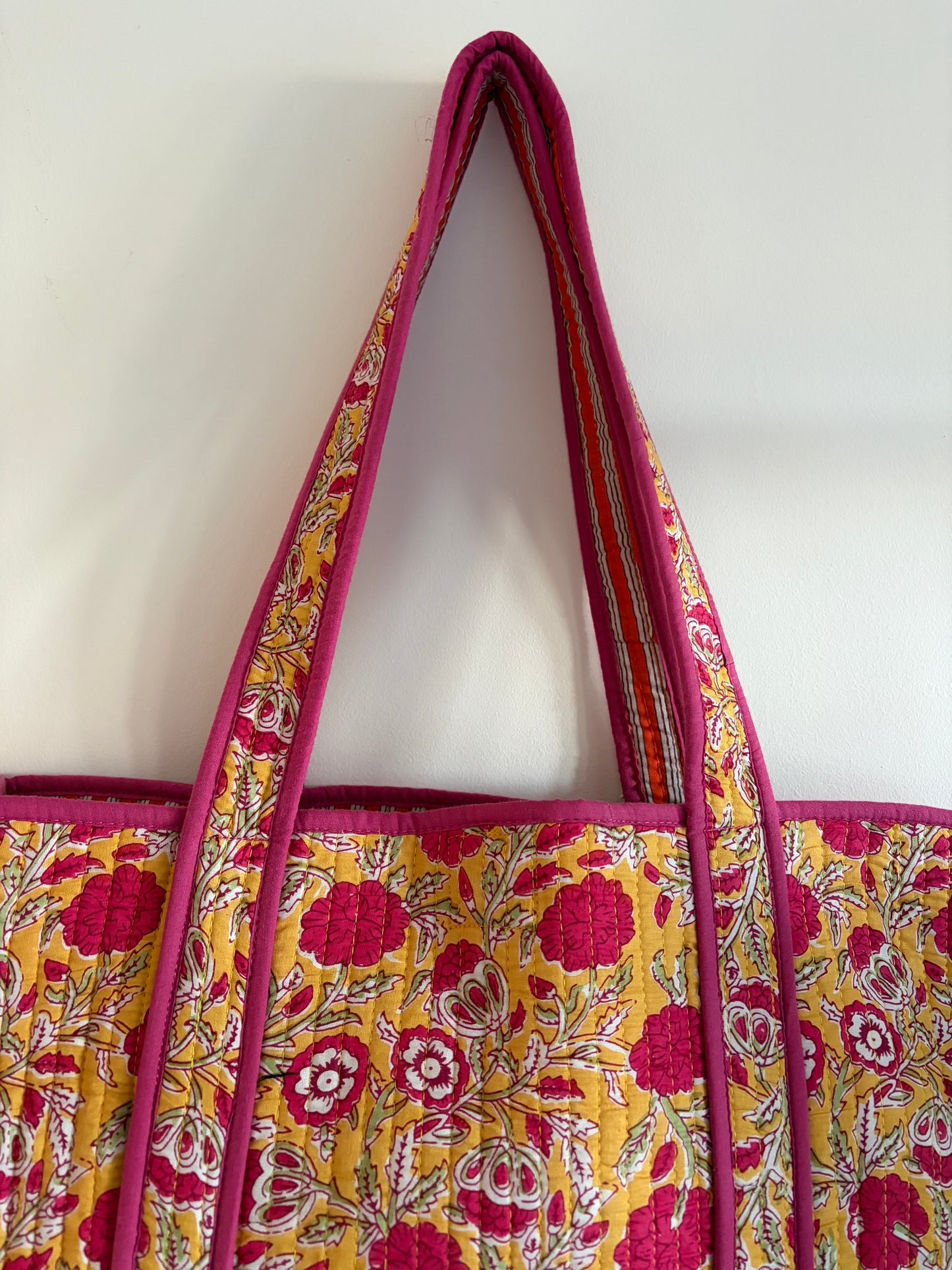Floral patterned bag with pink and yellow design on a white background