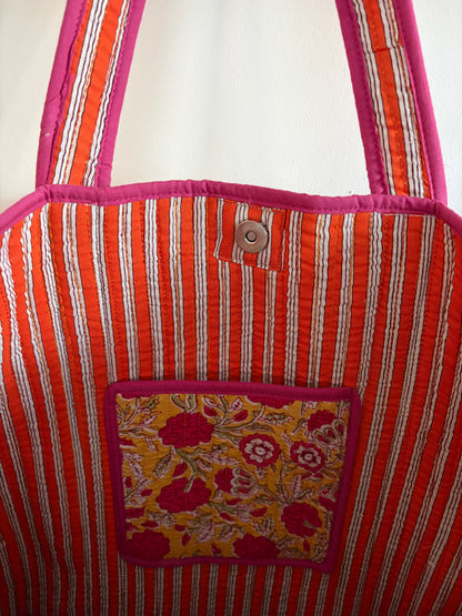 Striped fabric bag with a floral pocket on a white background