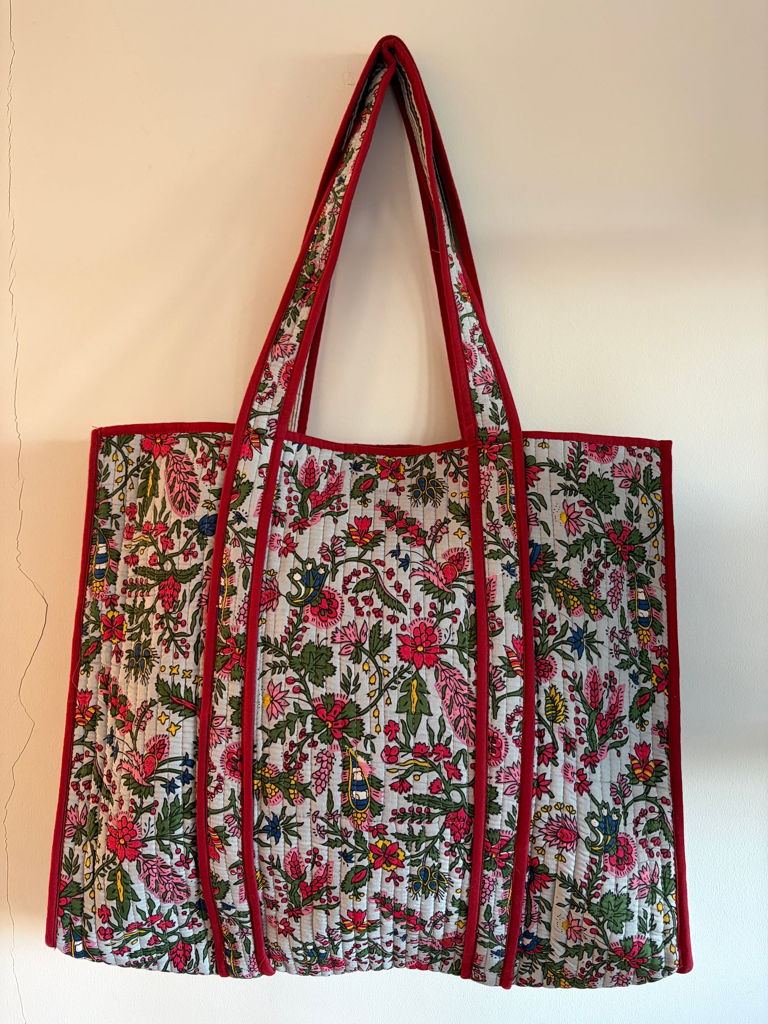 Floral patterned bag with red accents on a beige background