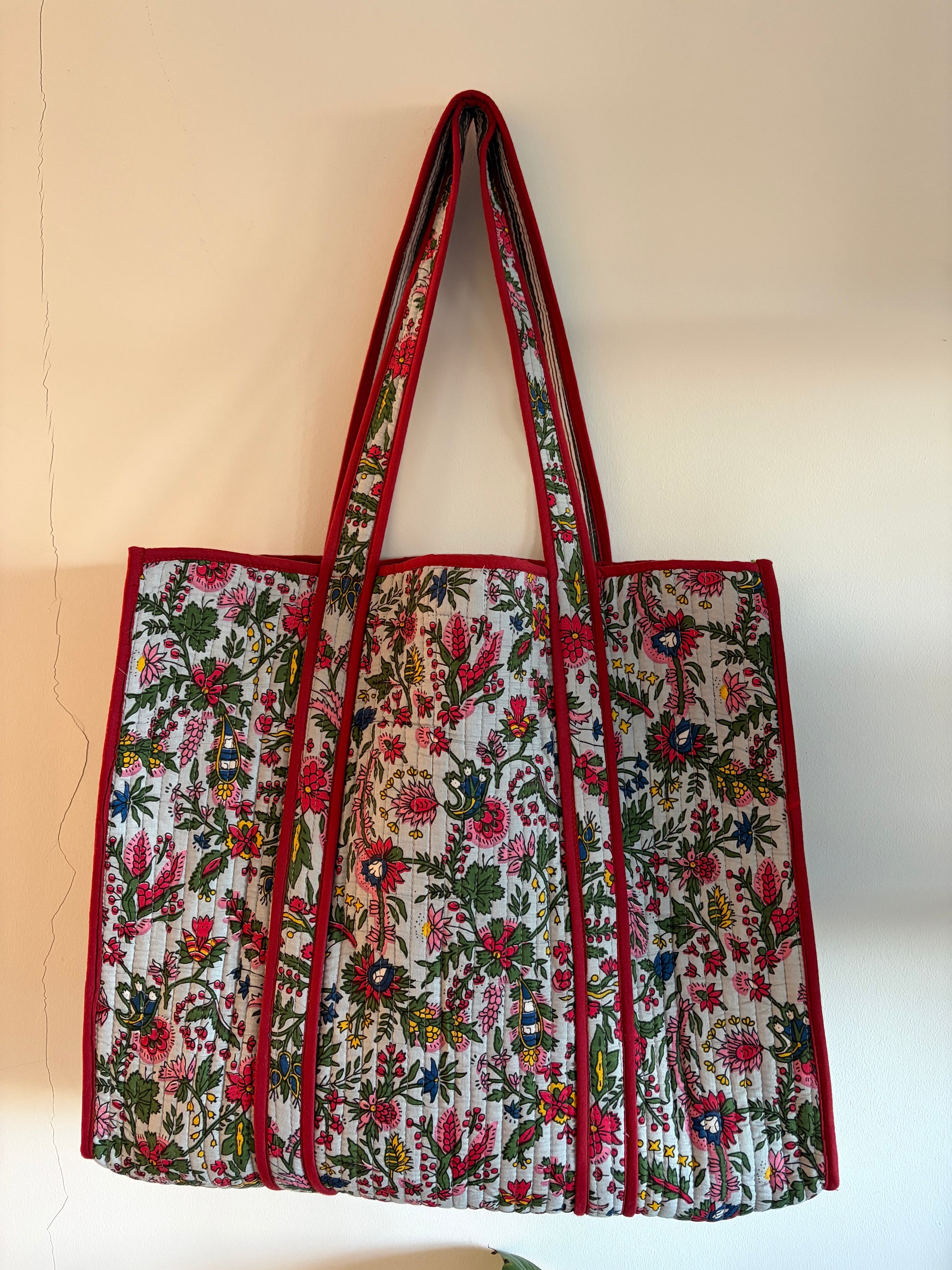 Floral patterned bag with red accents on a beige background