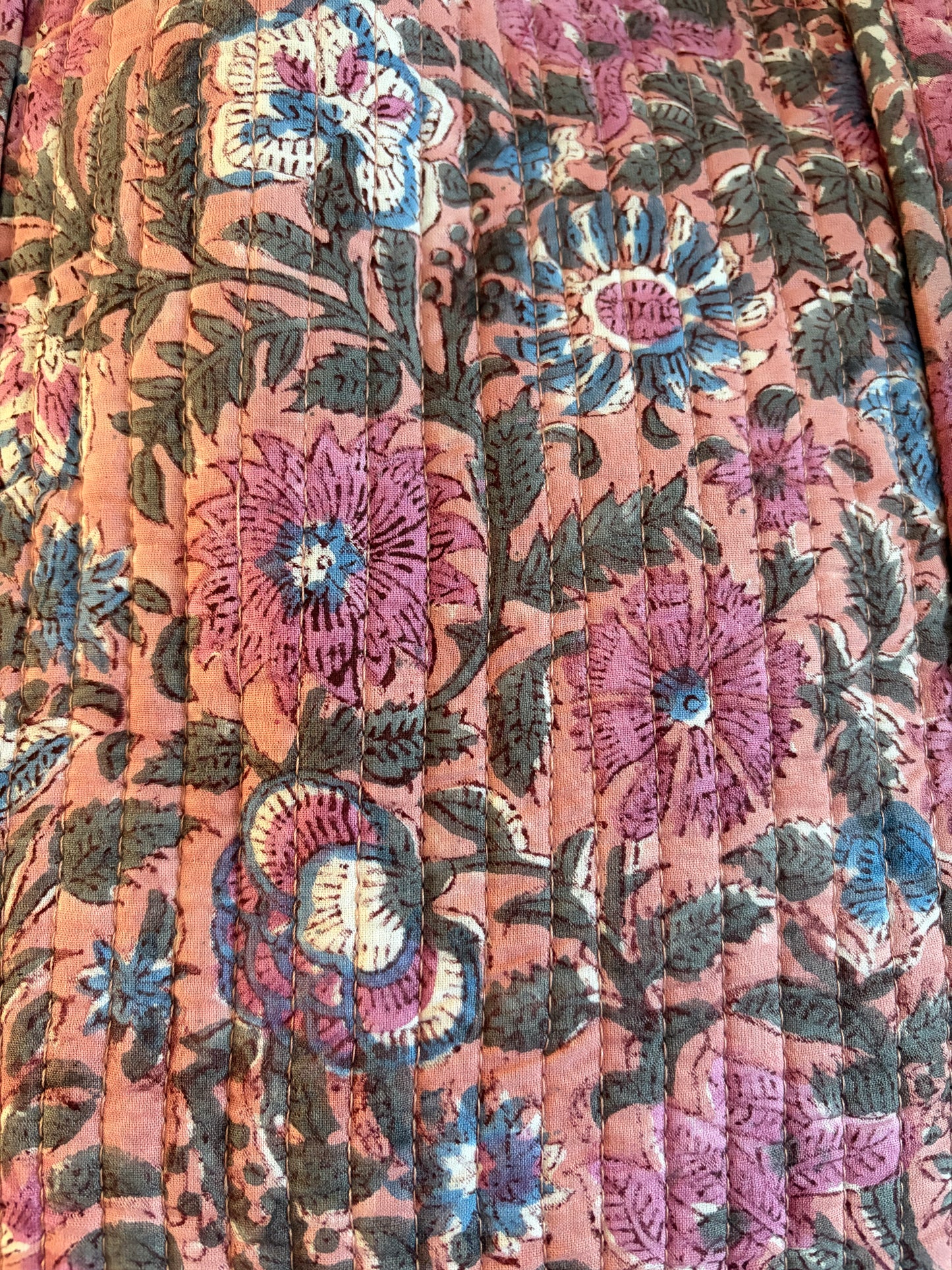 Close-up of floral pattern on pink block print cotton quilted tote bag, featuring vibrant flowers and elegant stitching.