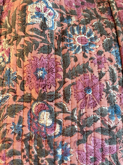 Close-up of floral pattern on pink block print cotton quilted tote bag, featuring vibrant flowers and elegant stitching.