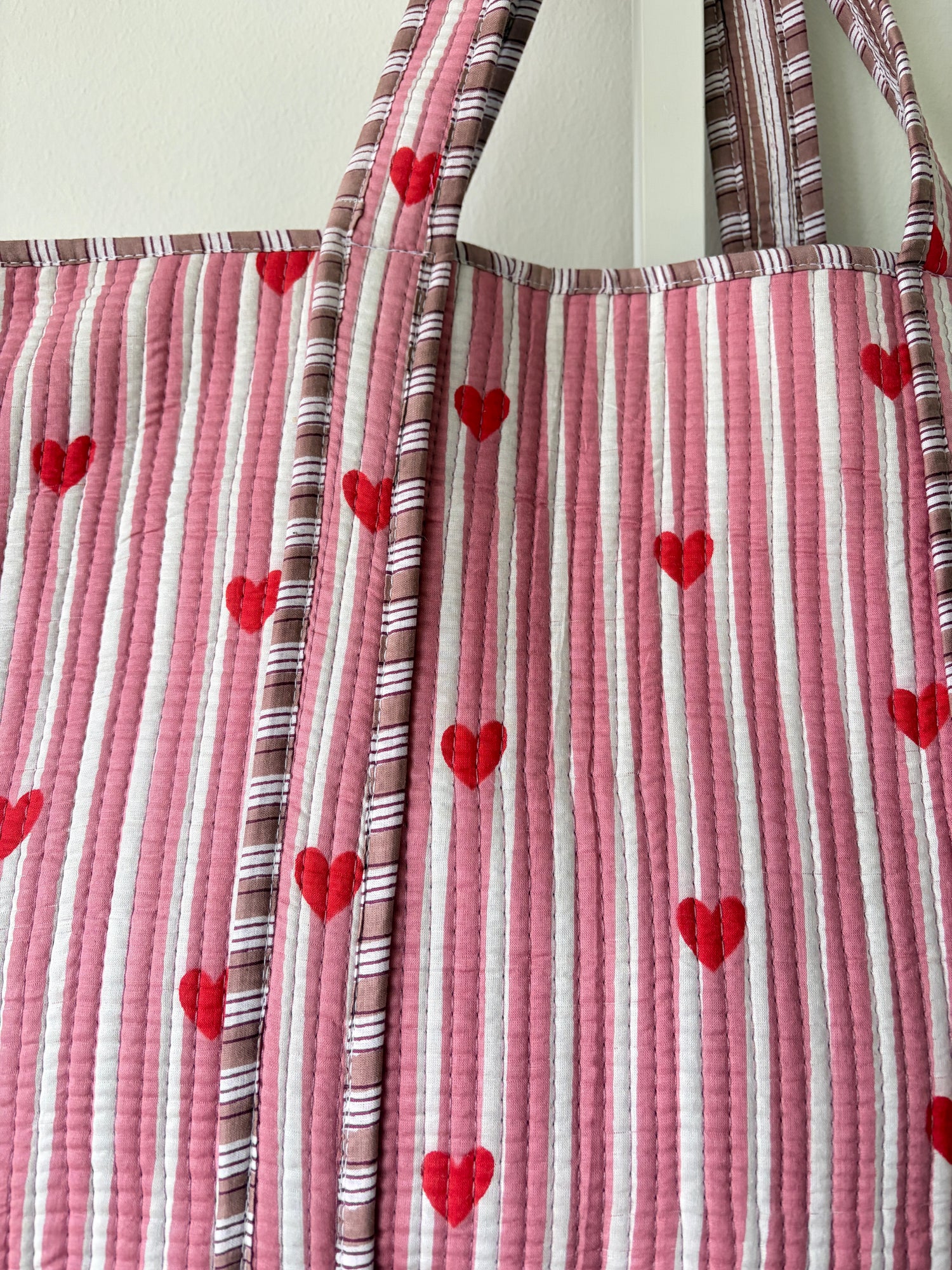 Fabric with red heart patterns on a striped background