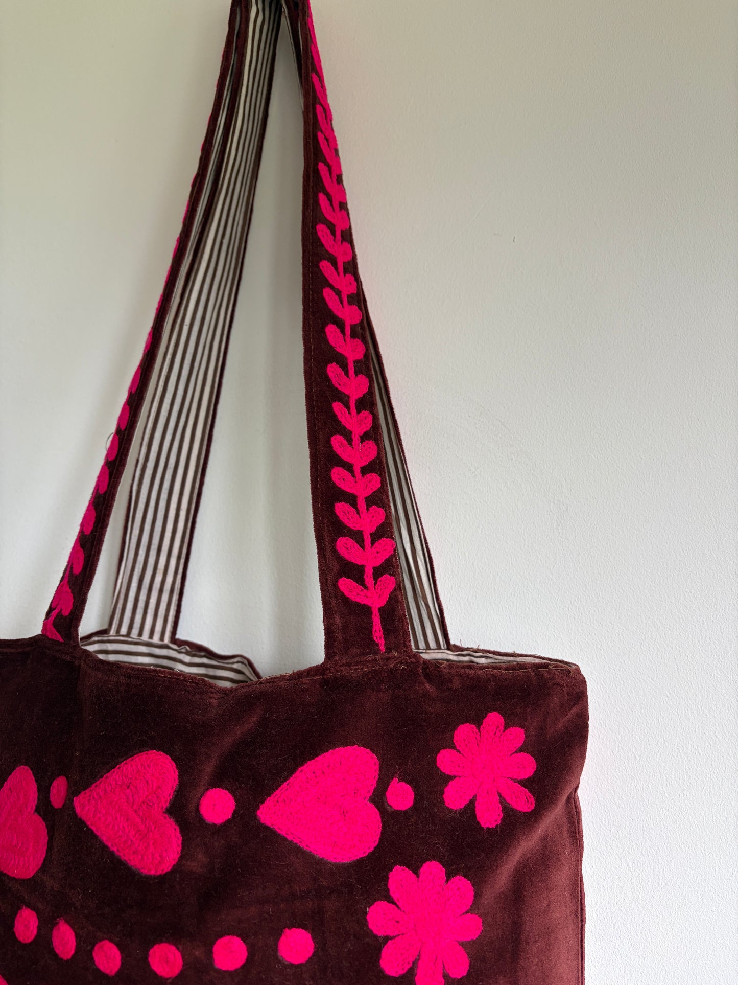 Brown tote bag with pink 'PEACE' text and heart designs on a plain background