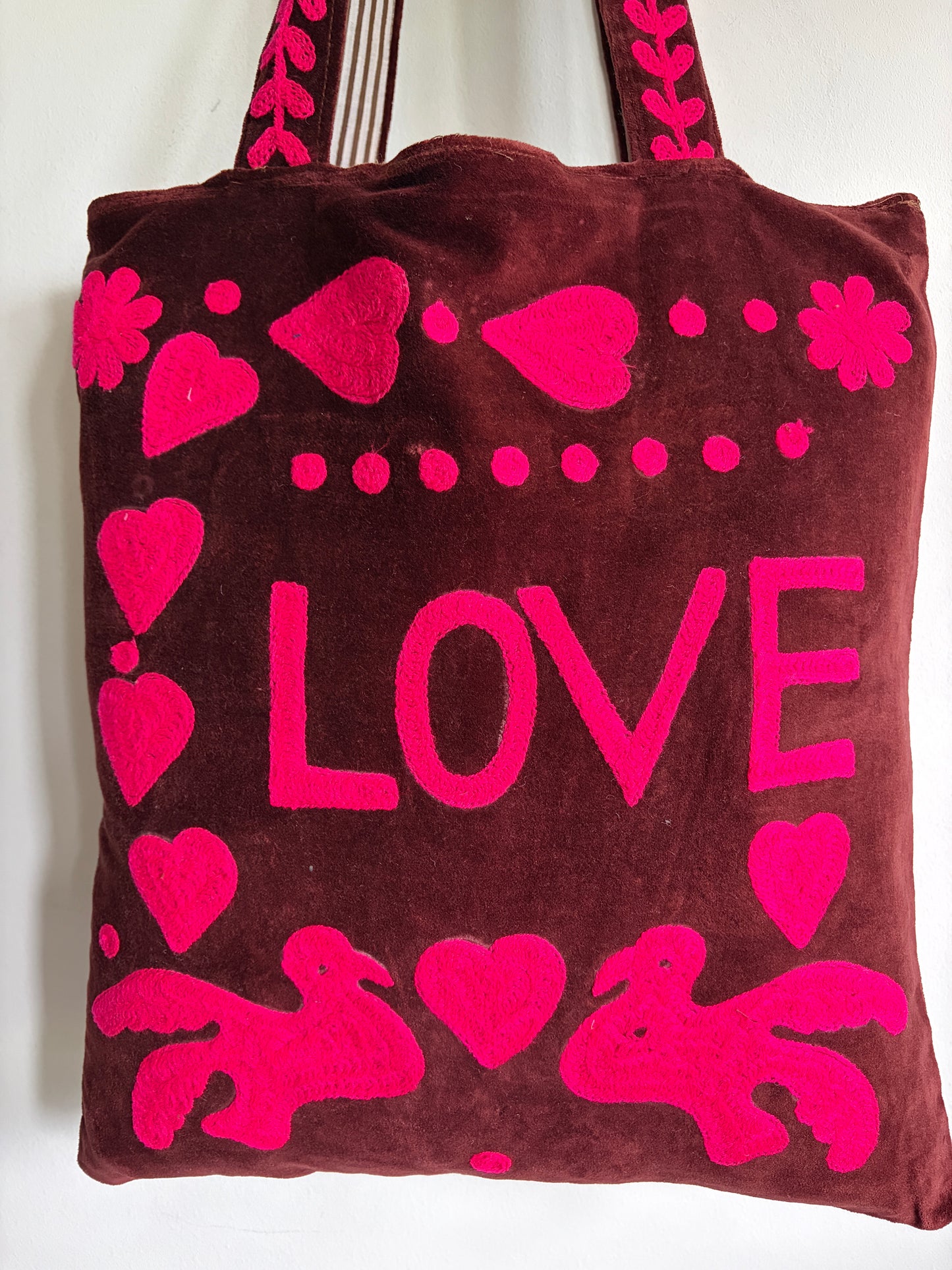Brown tote bag with pink 'PEACE' text and heart designs on a plain background