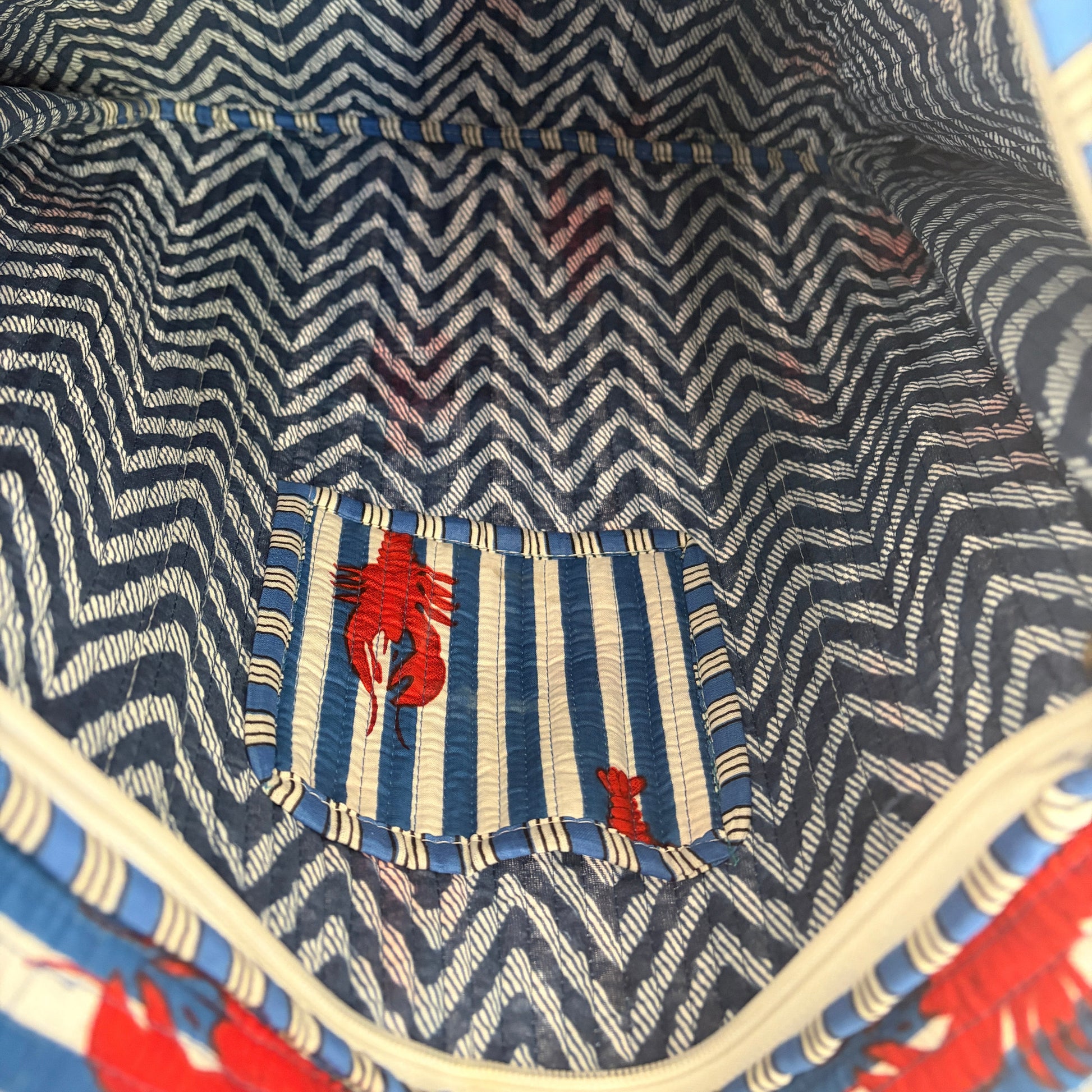 Close-up of a bag with a zigzag pattern and red lobster design.
