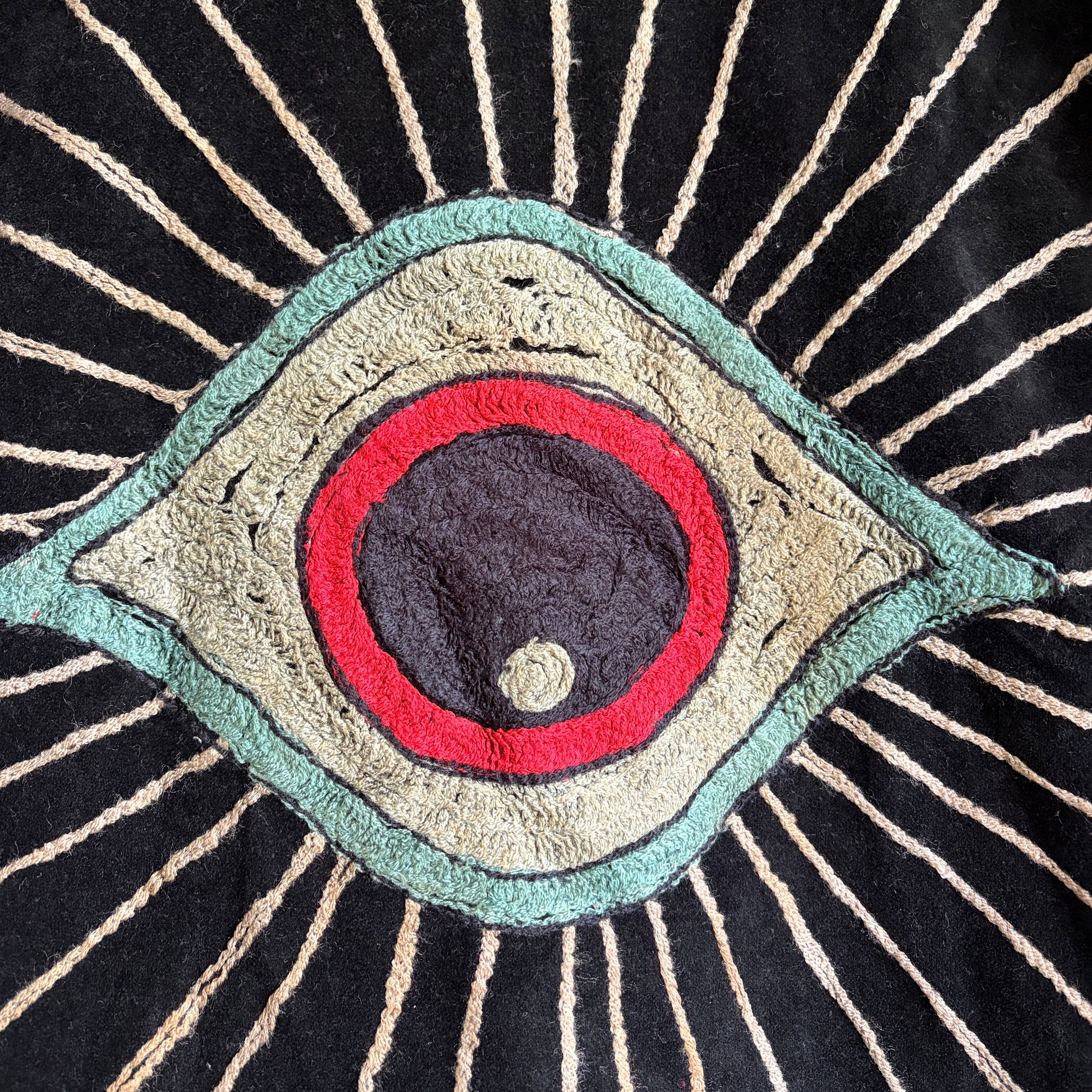 Colorful embroidered jacket on a hanger against a white background