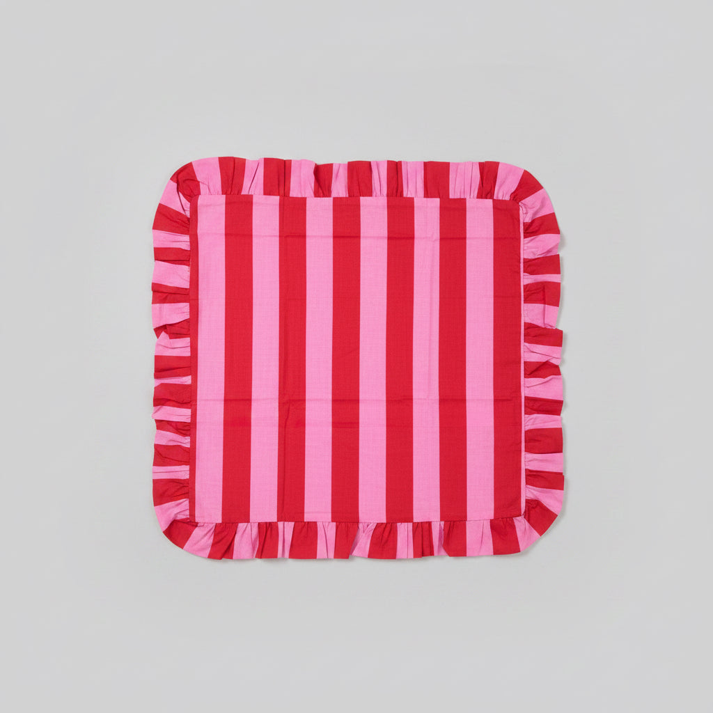 Red and pink striped cushion on a gray surface