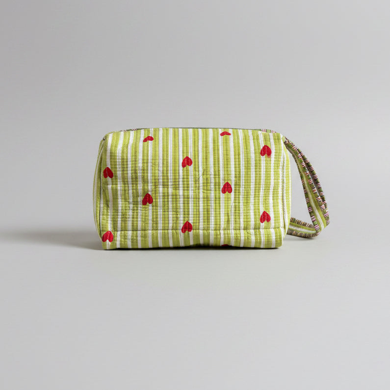 Quilted green and white make up bag with red hearts.