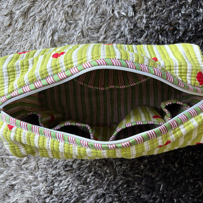 Quilted green and white make up bag with red hearts.