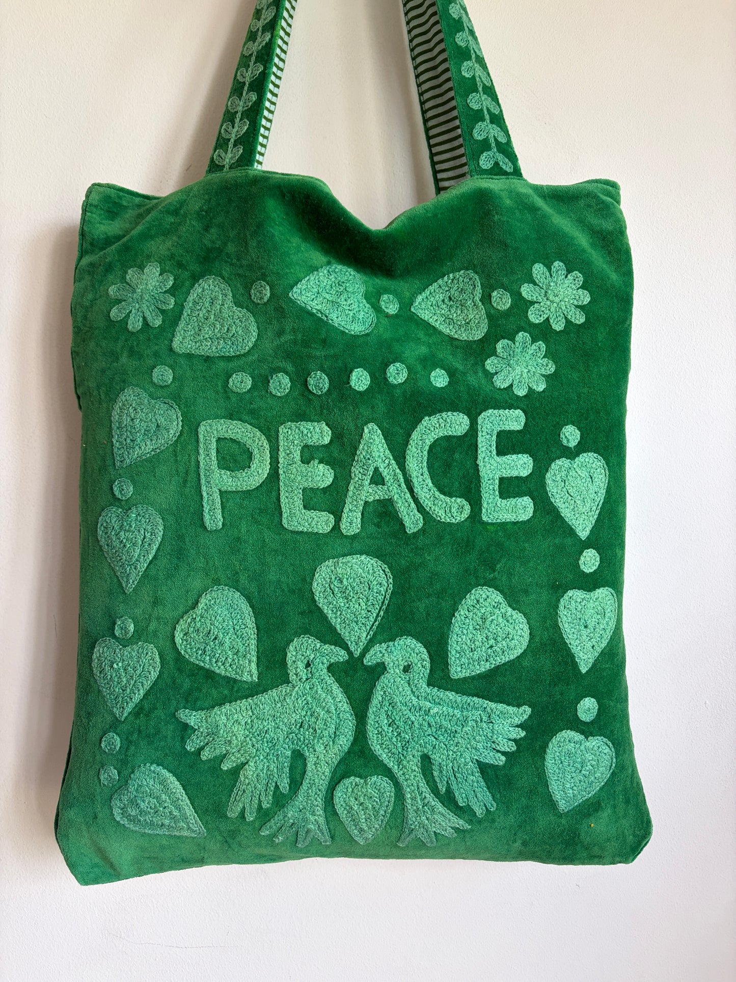 Green Suzani Velvet bag with blue hearts and 'LOVE' on a beige background