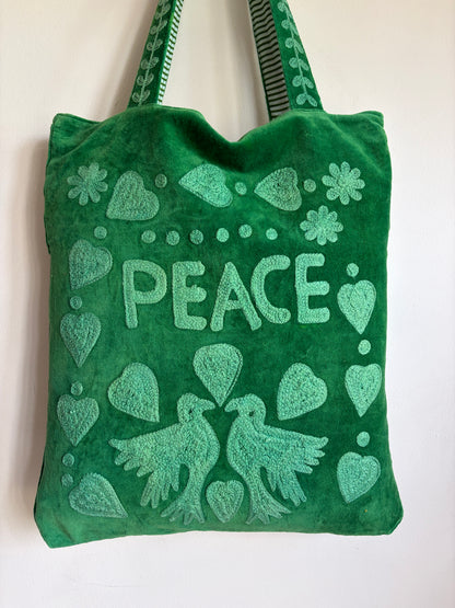 Green Suzani Velvet bag with blue hearts and 'LOVE' on a beige background