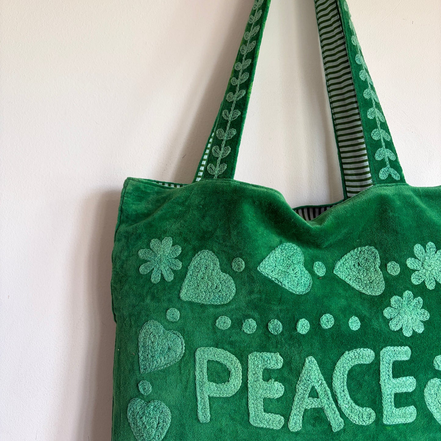 Green Suzani Velvet bag with blue hearts and 'LOVE' on a beige background