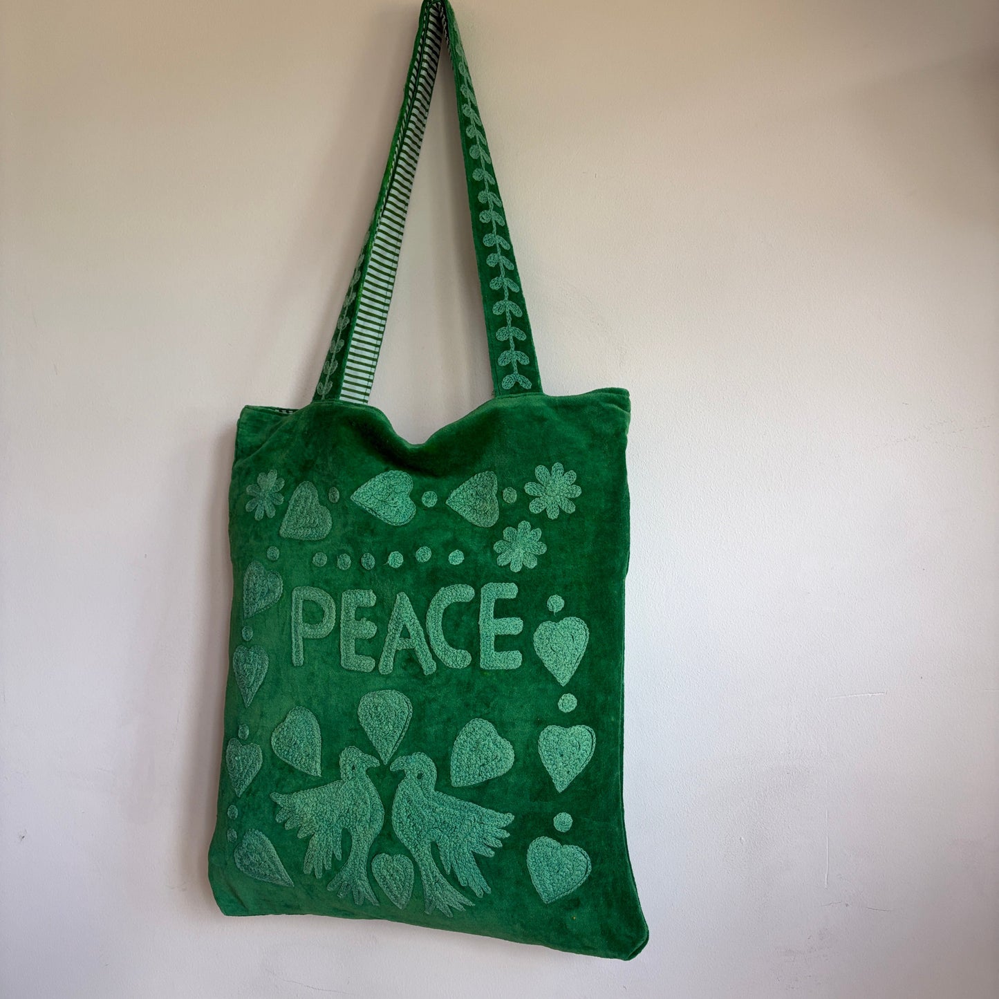 Green Suzani Velvet bag with blue hearts and 'LOVE' on a beige background