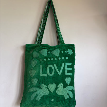 Green Suzani Velvet bag with blue hearts and 'LOVE' on a beige background
