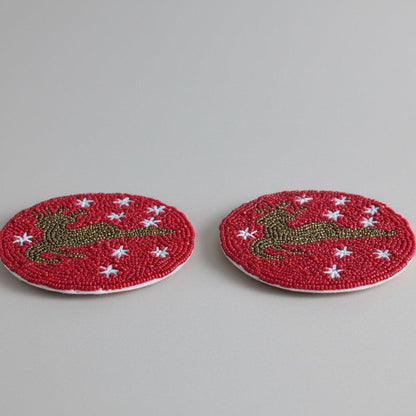 Red beaded coasters featuring a Reindeer silhouette and white star details. 