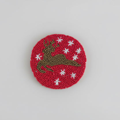 Red beaded coasters featuring a Reindeer silhouette and white star details. 