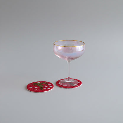 Red beaded coasters featuring a Reindeer silhouette and white star details. 