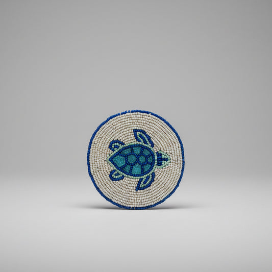 A round beaded coaster featuring a sea turtle design. 
