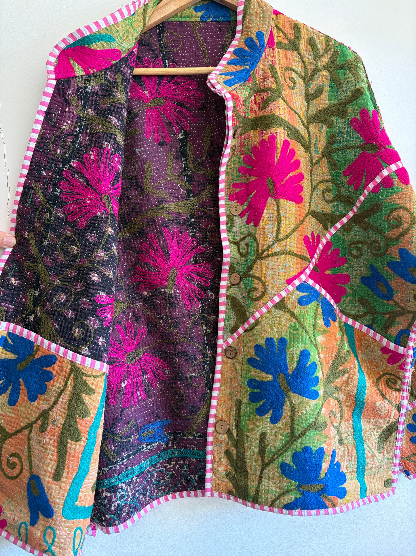 Colorful embroidered Suzani Jacket with floral patterns on a white background