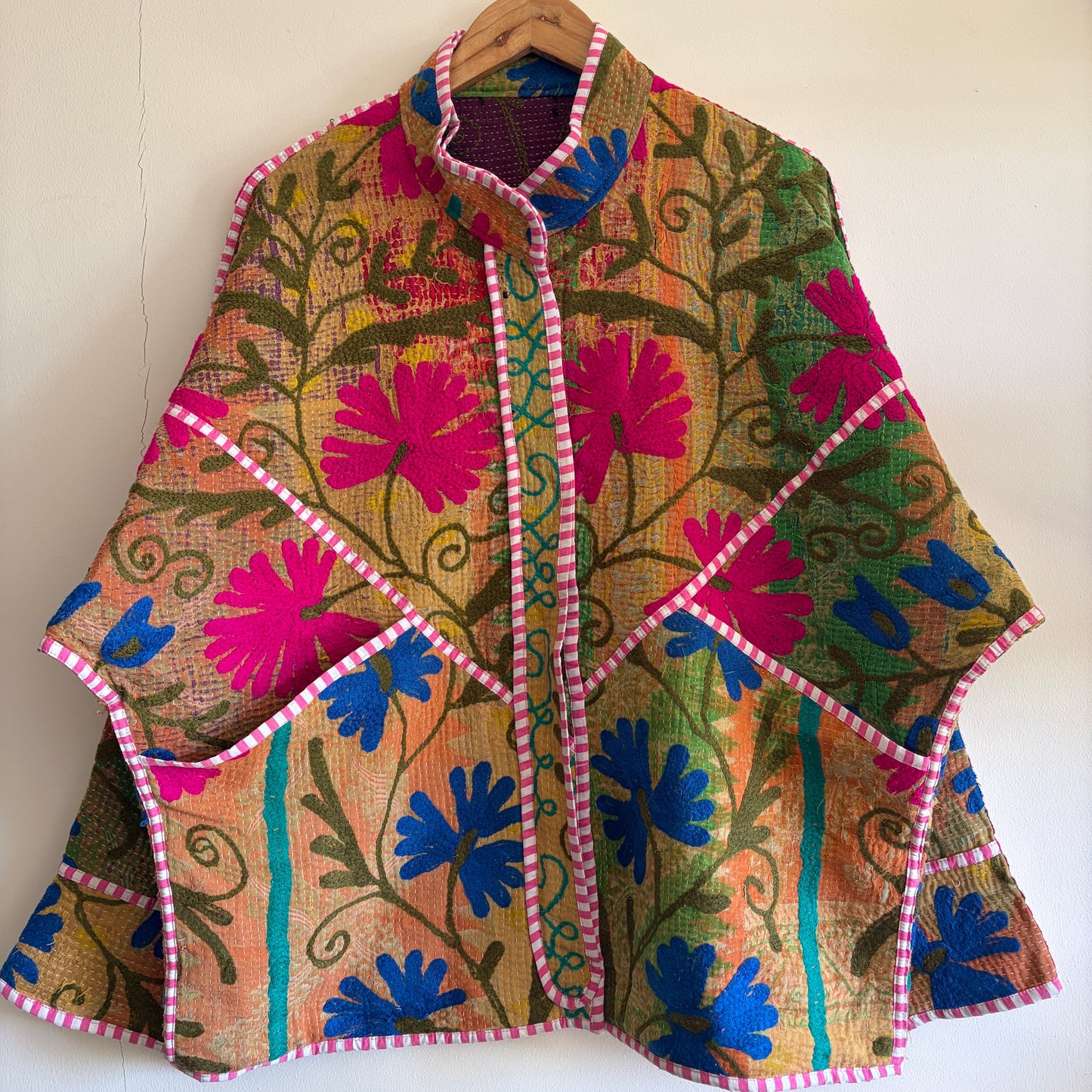 Colorful embroidered Suzani Jacket with floral patterns on a white background