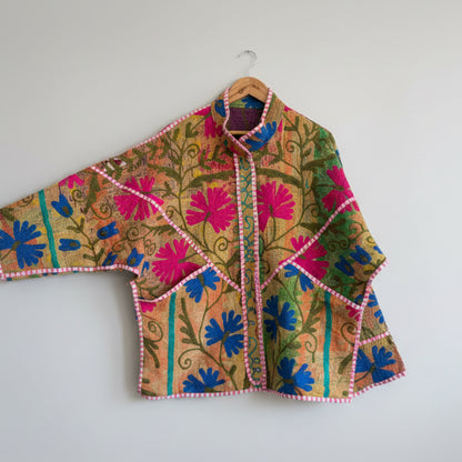 Colorful embroidered Suzani Jacket with floral patterns on a white background