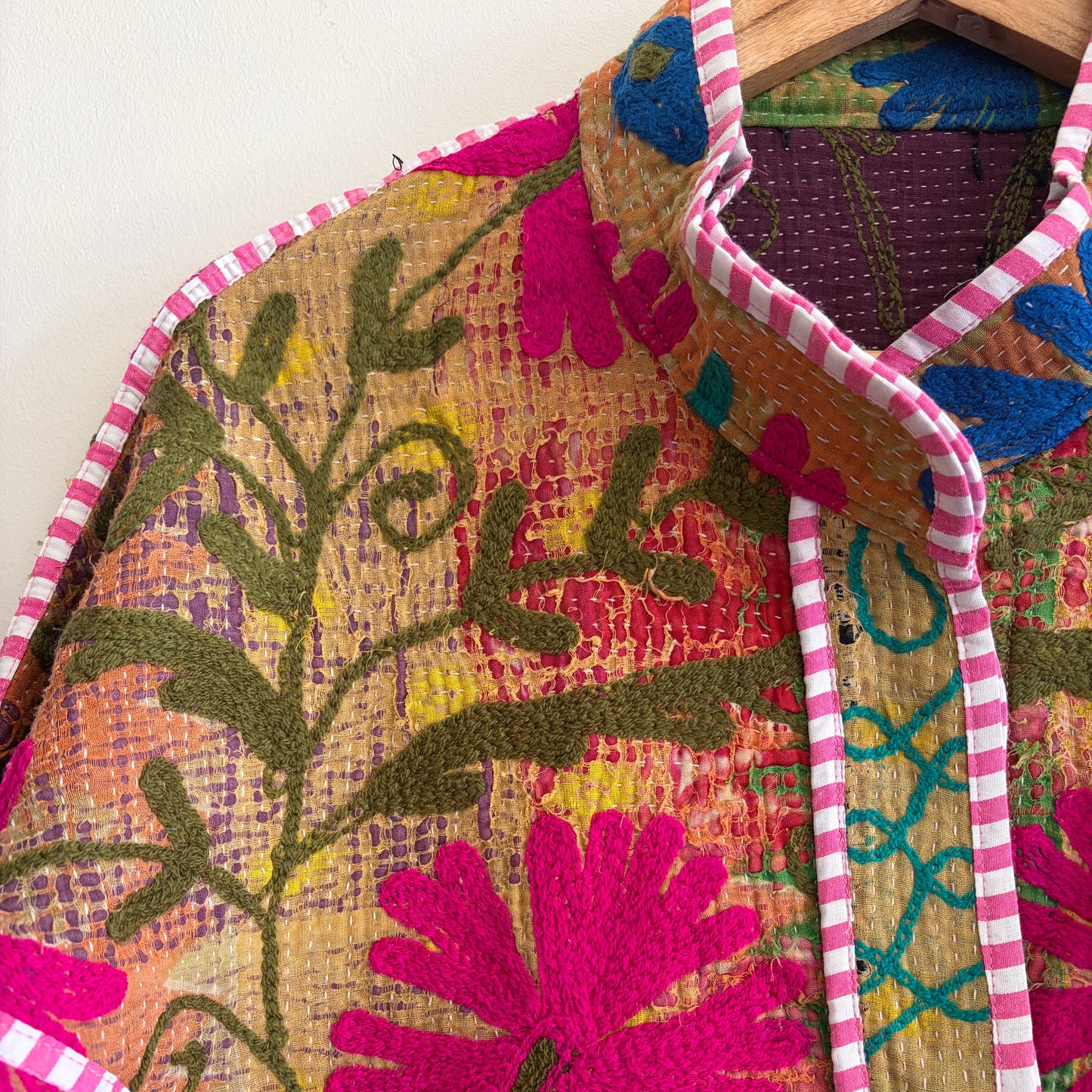 Colorful embroidered Suzani Jacket with floral patterns on a white background