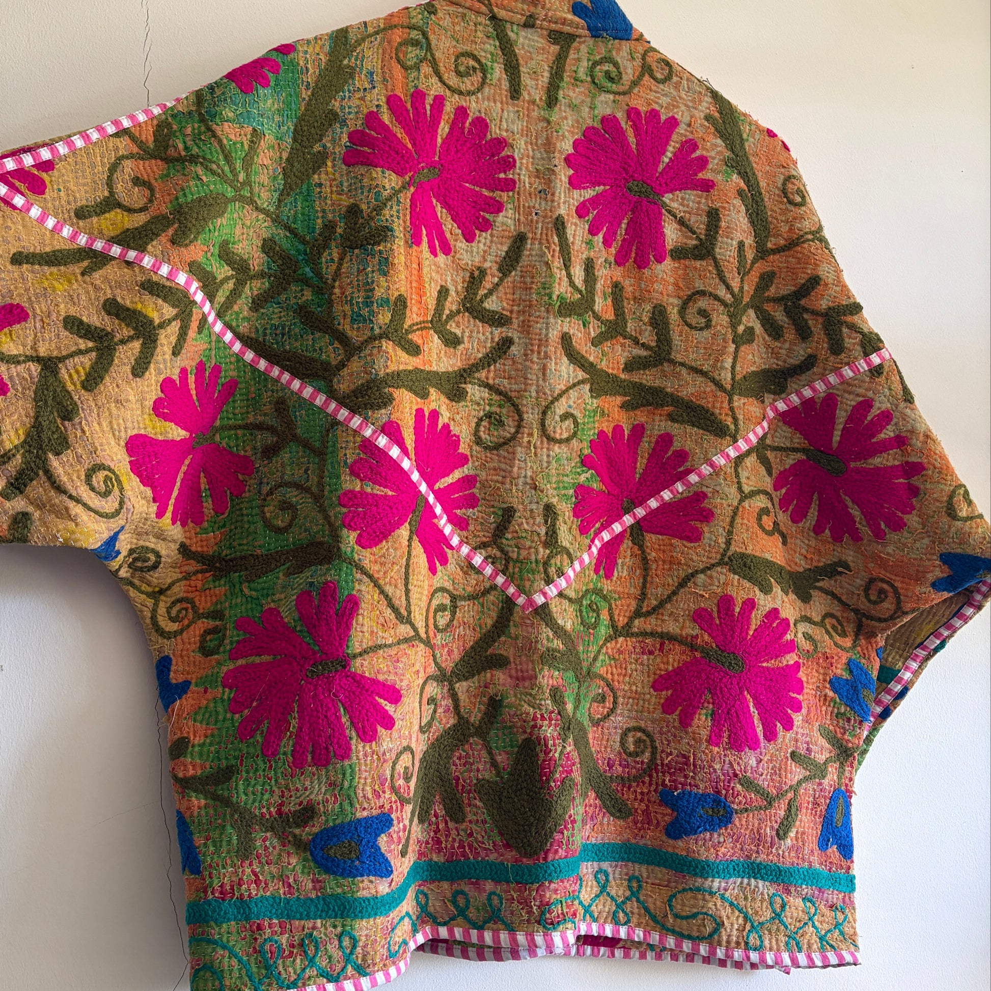 Colorful embroidered Suzani Jacket with floral patterns on a white background