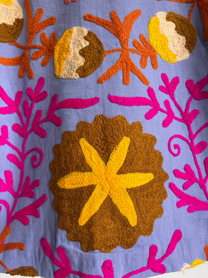 Colorful embroidered fabric with starfish and floral patterns on a blue background