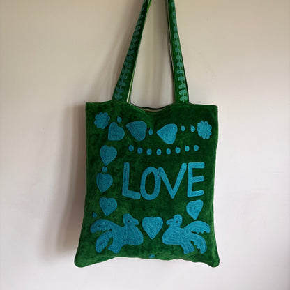 Green Suzani Velvet bag with blue hearts and 'LOVE' on a beige background